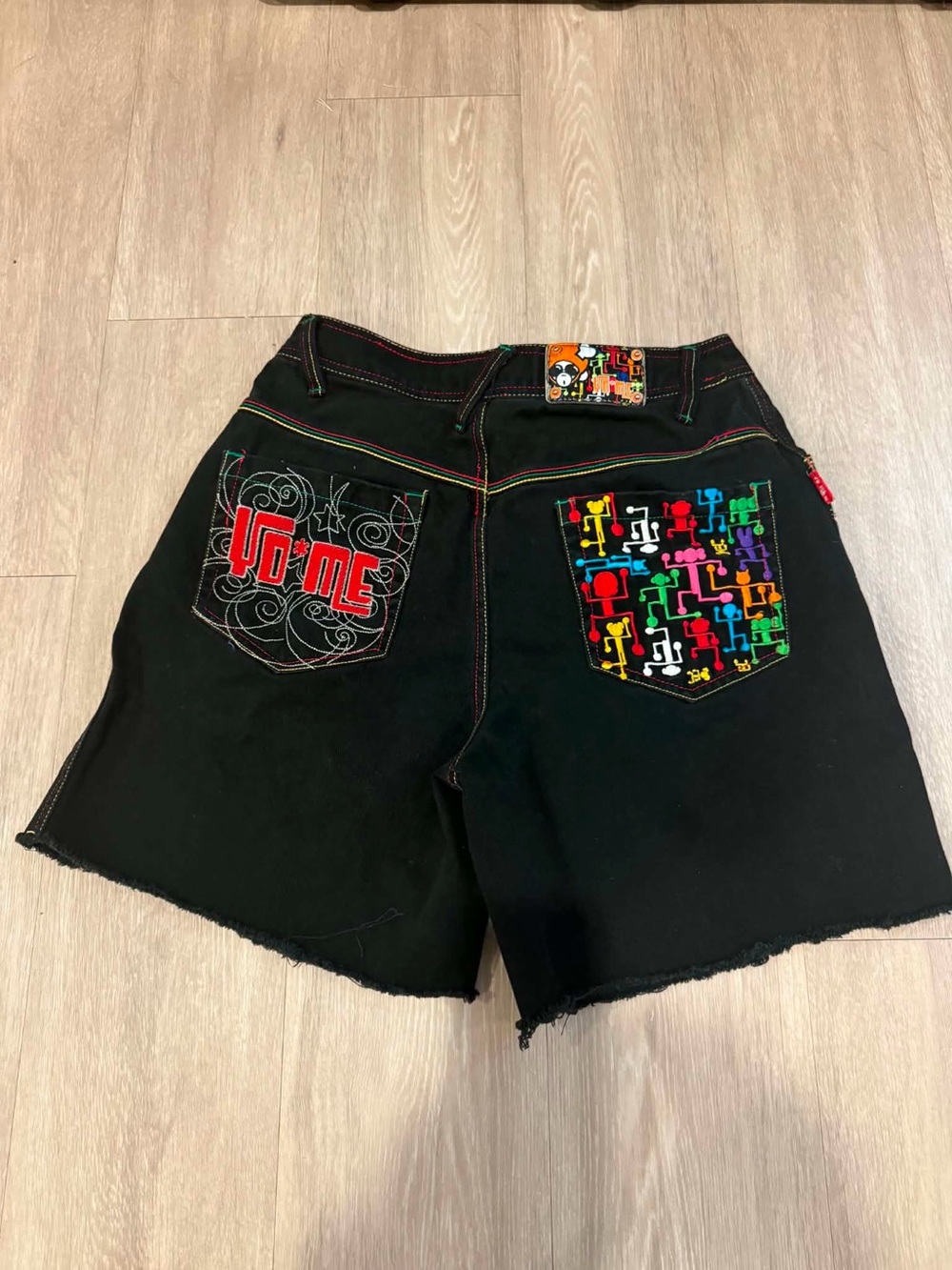 YO*ME brand black denim jorts featuring intricate colorful embroidery